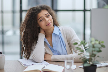 Tired business woman sitting at office desk and working