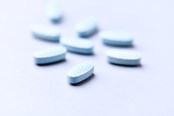 Multivitamin tablets on bright paper background. Close up. Copy space.