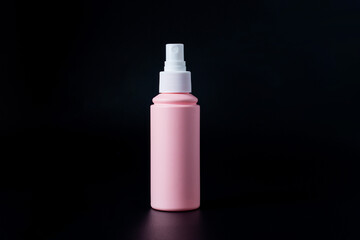 Cosmetic pink bottle. Womens cosmetic accessory for makeup on black background.