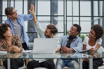 Successful business people giving each other a high five in a meeting