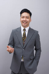 arafed asian man in a suit and tie standing with his hands out