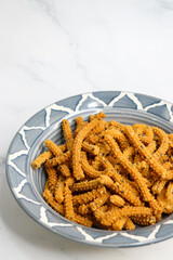 Crunchy fried homemade Chakli sticks with sesame seeds. Chakli is a savory snack from India made out of rice, mixed yellow and green lentils along with spices. Mostly eaten during Diwali festival