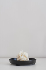Yarn ball shaped soy wax candle on a metal tray. Minimalistic home decor. Eco-friendly decorative candle