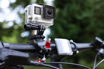 Modern action camera with mount on bicycle outdoors, closeup