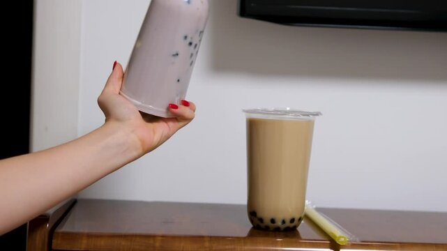 Milk bubble tea with tapioca pearls in glass, gray background. Bubble Tea drink