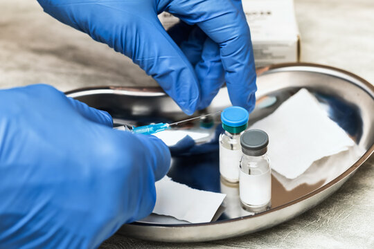 Gloved hand holding syringe preparing for vaccination
