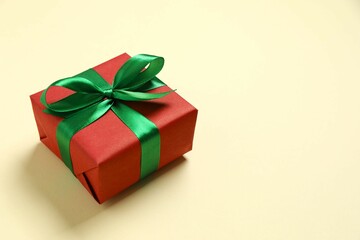 Beautiful gift box tied with bow on color background 