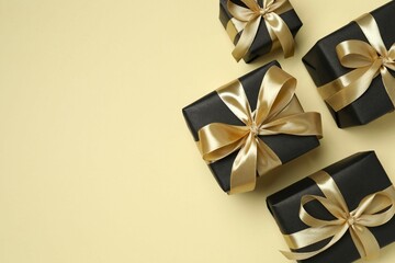 Beautiful gift boxes tied with golden bows on color background 