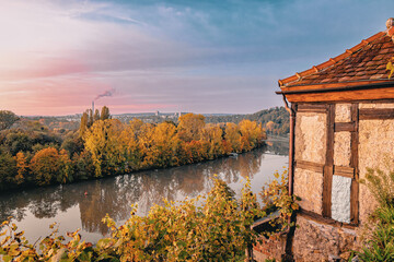 Blick auf einen Fluß , den Neckar, an einer Winzerhütte vorbei. Herbstlich gefärbte Bäume...