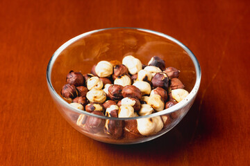 Hazelnut nut in glass plate on wooden background