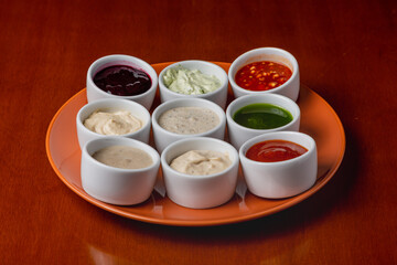 Assortment of sauces on a plate on a wooden background