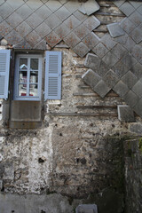 Façade en ardoise qui sur une maison qui manque d'entretien