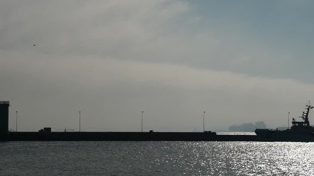 LNG ship on the horizon in Mukran. a peaceful scene overshadowed by controversial energy transports.This is a video excerpt of 9 seconds. The video is 47 MB in size. The frame rate is 50 pps.