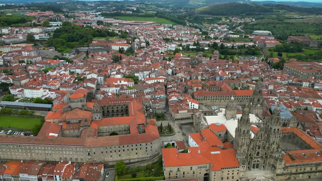 Aerial view of Santiago de Compostela city. View of famous Cathedral of Santiago. Panoramic aerial view of all city. Rooftops of Santiago. Travel destination. Tracking right above the Obradoiro Square