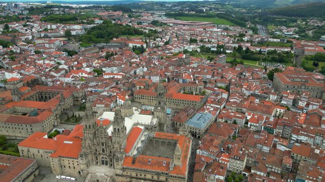 Aerial view of Santiago de Compostela city. View of famous Cathedral of Santiago. Panoramic aerial view of all city. Rooftops of Santiago. Drone circling around Cathedral. Famous travel destination.