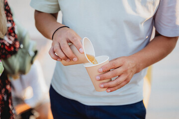 A man is currently engaged in the act of carefully pouring a certain type of liquid or substance...
