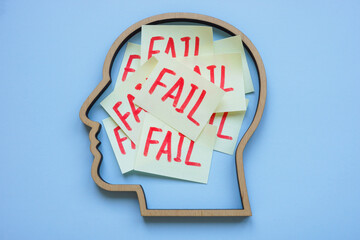 Head outline with the word fail inside. Self-doubt and fear of failure.