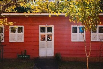 Charming red wooden building with white shutters.