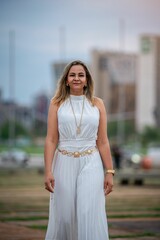Woman in white dress poses in front of the iconic Cathedral, showcasing modern architecture.
