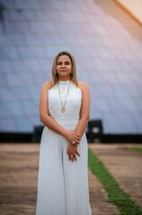 Woman in white dress poses in front of the iconic Cathedral, showcasing modern architecture.