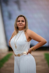 Woman in white dress poses in front of the iconic Cathedral, showcasing modern architecture.