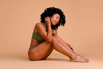 No filter studio photo of dreamy pretty woman underwear accepting imperfect skin empty space isolated beige color background
