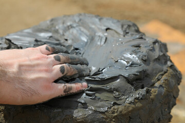 mar muerto jordania mar salado recipiente de barro mujer hombre gente dandose barro con la mano en el cuerpo 4M0A1694-as24