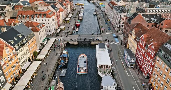 Aerial drone view of boats on the Nyhavn waterfront, canal and entertainment district in Copenhagen, Denmark in daylight