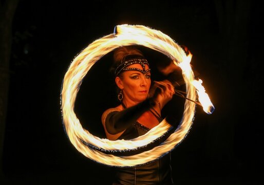 Fire dancer creating a circle of fire by spinning flaming poi