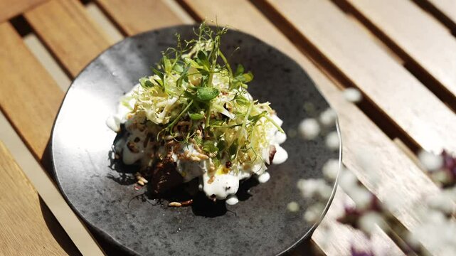 Top view of a dish garnished with some vegetables and a white sause