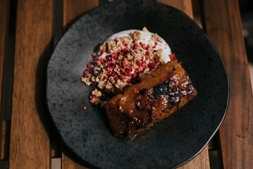 A black designer plate full of brunch on a wooden table