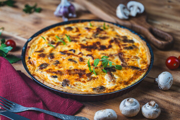 Quiche Laurent according to a traditional French recipe. Pie with chicken and mushrooms on a plate on a blue background. High quality photo