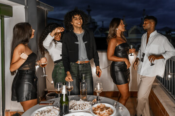 Elegant young friends celebrating a night party in a roof