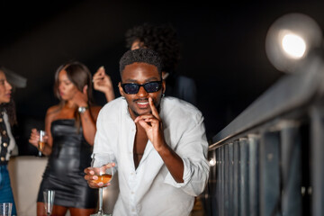 Man gesturing while dancing and drinking alcohol during roof party