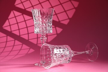Two elegant wine glasses on pink background