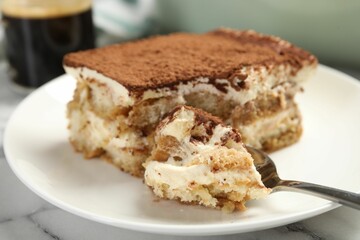 Piece of tasty tiramisu on white marble table, closeup