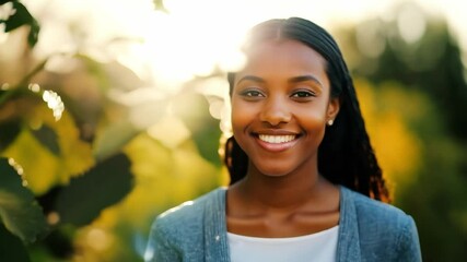 Young woman radiating joy with sunlight creating a stunning flare behind her