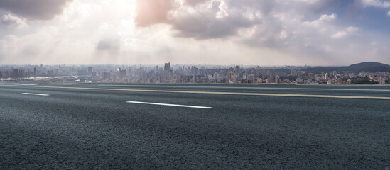 Fototapeta premium Expansive Urban Landscape with Roadway Under Dramatic Sky