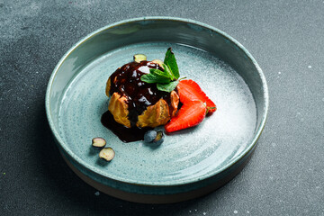 Custard cake with chocolate and strawberries. On a dark stone background.
