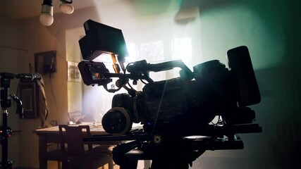 movie camera on the slider in the backlight from the window, the rays of the sun in a smoky room