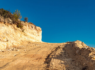 Fototapeta premium Ascending Dirt Road: Blue Sky and Cliff in Cyprus Mountains.