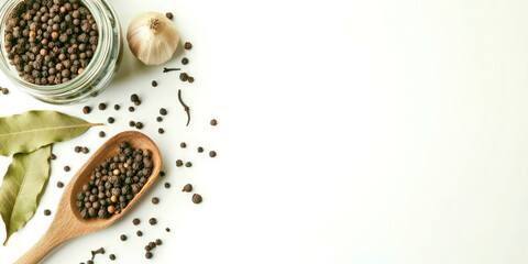 A jar of black pepper and a spoonful of garlic are on a white background