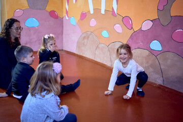 5-7 year old children at an acting class with their teacher, extracurricular activities