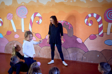 5-7 year old children at an acting class with their teacher, extracurricular activities