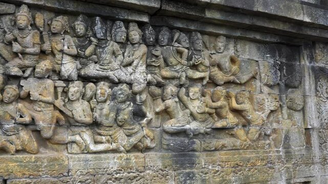 Indonesia,Jawa Island,Yogyakarta,Unesco world heritage Borobudur Temple's inside,wall relief close up.camera slides slowly from right to left and shows the relief in details,army of people on the wall