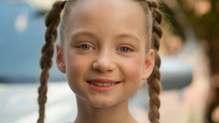 Close up portrait adorable cute happy smiling Caucasian little girl child kid schoolgirl pupil...
