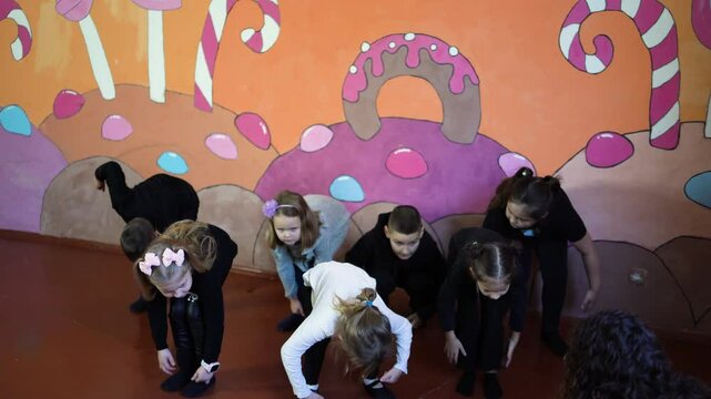  5-7 year old children at an acting class with their teacher, extracurricular activities