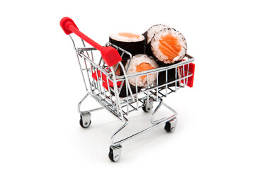 Shopping supermarket cart with delicious sushi rolls with fresh fish isolated on a white...