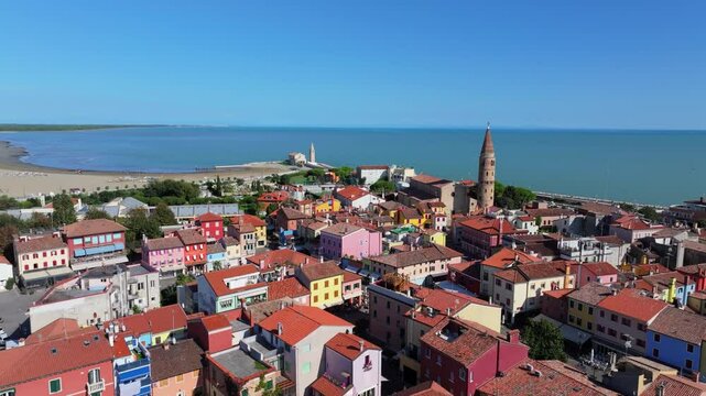 stunningly colorful aerial moving toward the landmarks of Caorle Italy, Duomo di Santo Stefano Protomartire, and the Madonna dell'Angelo on the Adriatic Sea