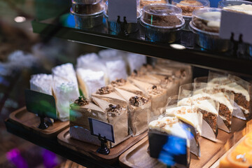 Cakes and sweets on the front of a small coffee shop, bokeh light background